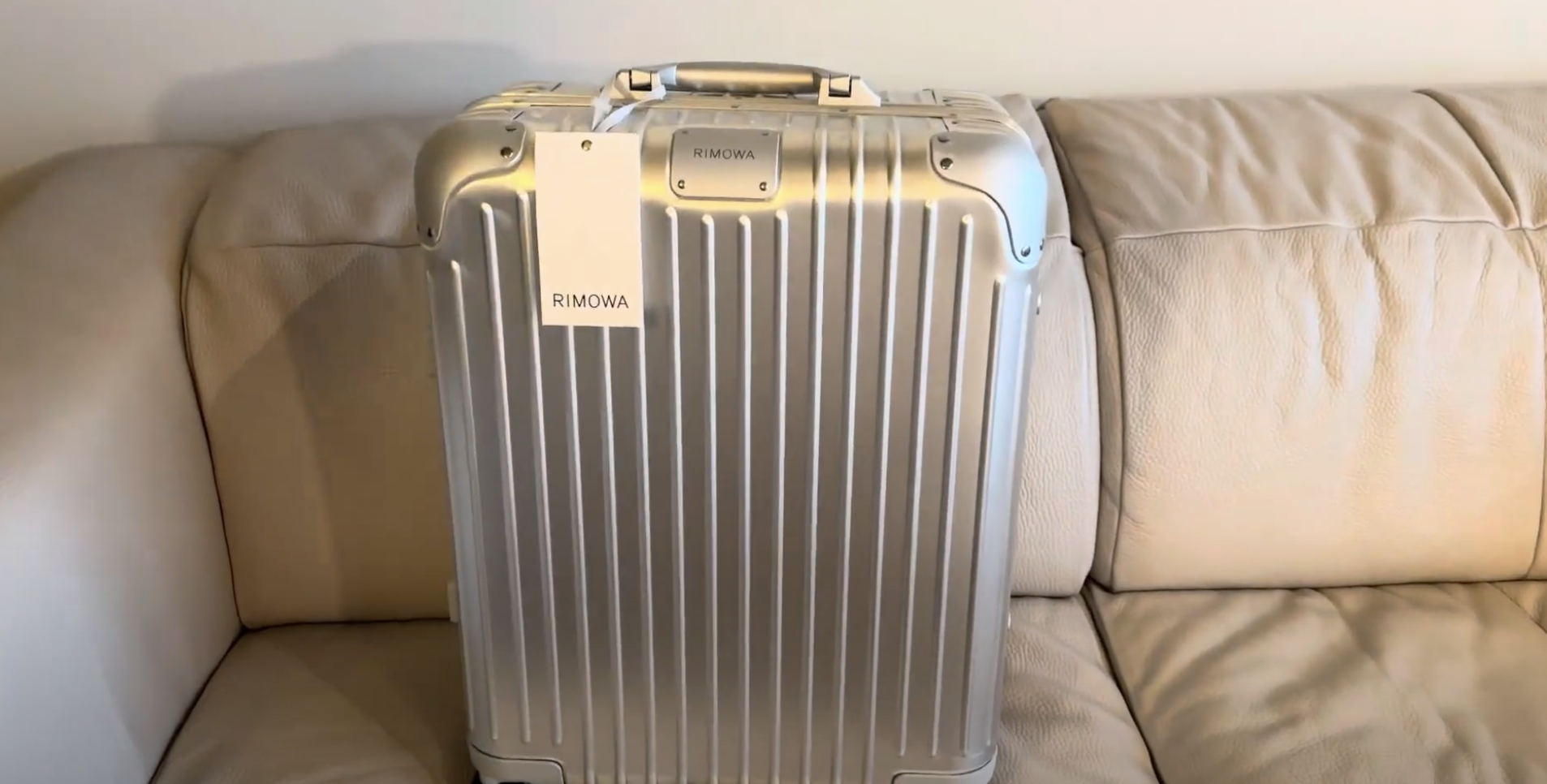 rimowa luggage on sofa