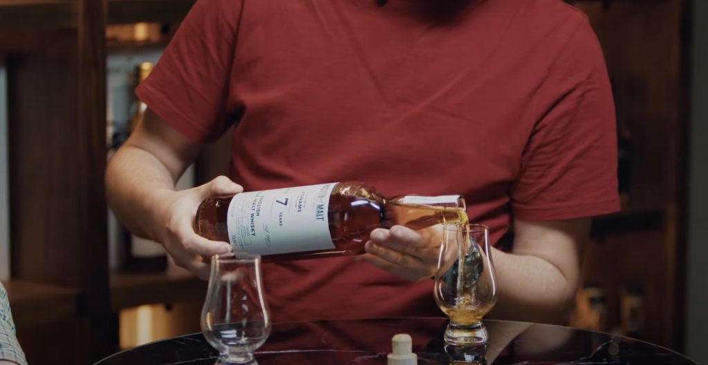 man pouring bottle of master of malt whiskey