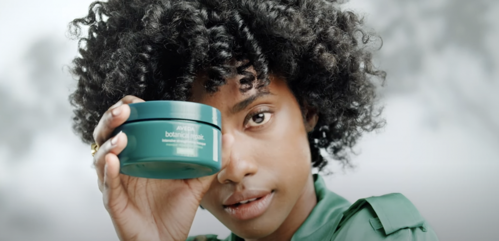 model holding aveda product container