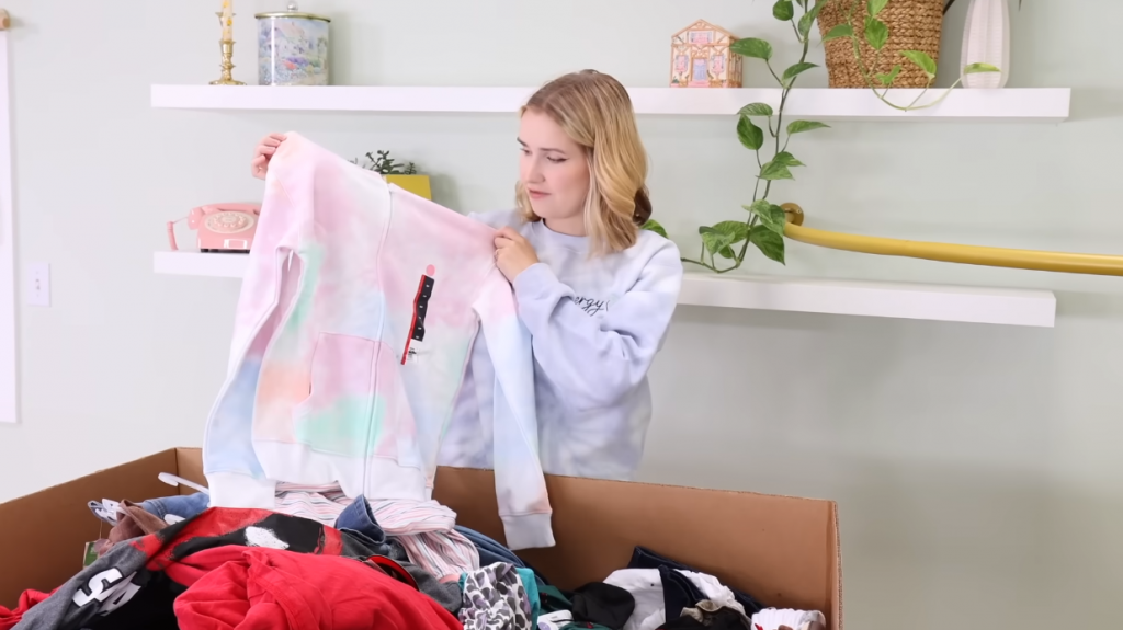 woman looking at a sweater from a shopping pallet