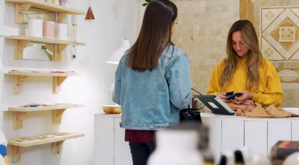 Woman talking to cashier at counter