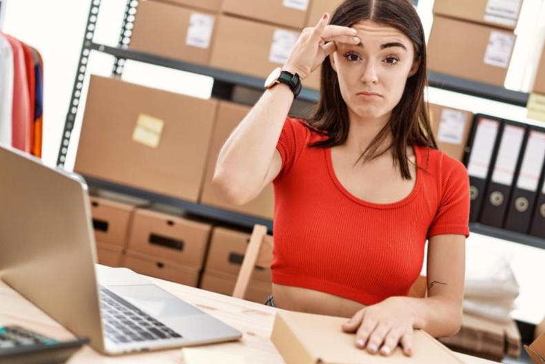 Young hispanic woman preparing order working at storehouse worried and stressed about a problem with hand on forehead nervous and anxious for crisis
